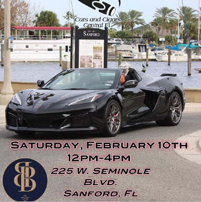 A sports car parked at the water front advertising Cars and Cigars