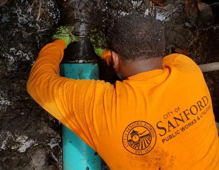 a public works employee working on a pipe