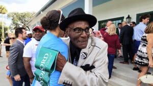 People hug in front of Mayfair Country Club during the ribbon cutting event
